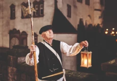 KO_Touristik_Nachtwaechter_v001_1_NM_8Z5A3483.webp © Koblenz-Touristik GmbH, Picture Colada Stadtführer, bekleidet als früherer Nachtwächter, hält Laterne und Hellebarde vor der Alten Burg in Koblenz © Koblenz-Touristik GmbH, Picture Colada