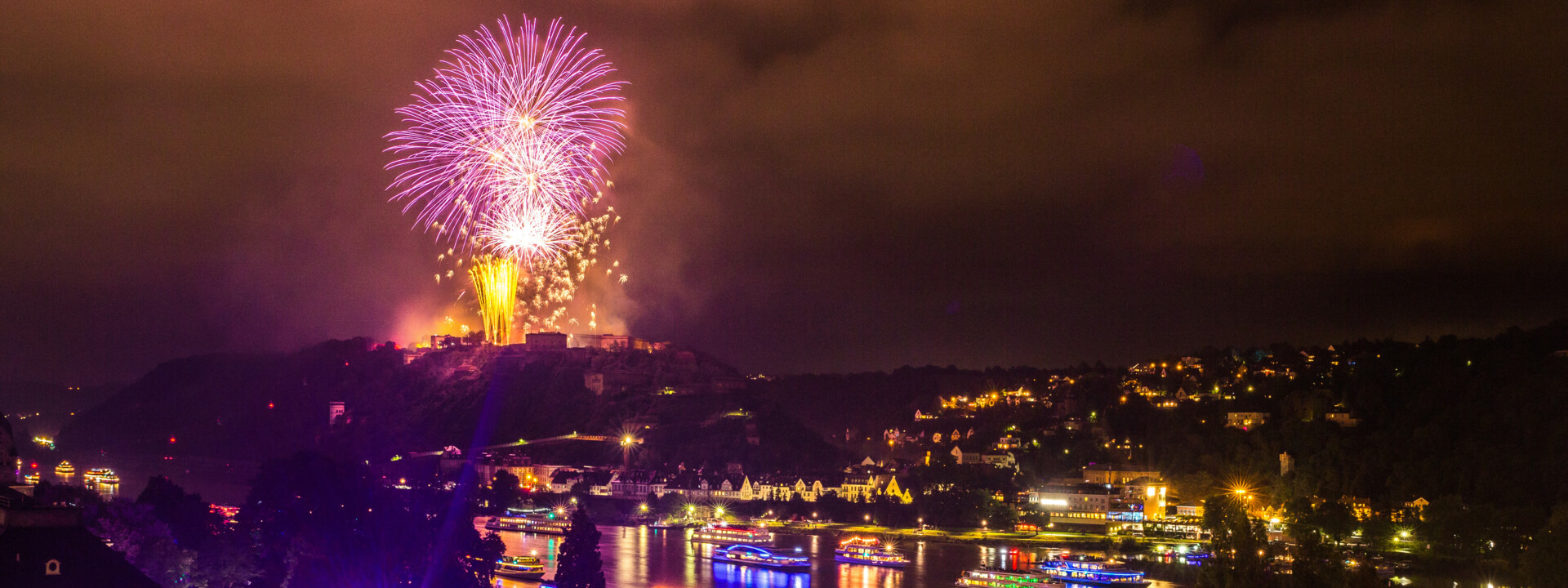 Feuerwerke über der Festung Ehrenbreitstein beleuchten den Nachthimmel. Farblich beleuchtete Schiffe fahren auf dem Rhein. ©Koblenz-Touristik GmbH, Henry Tornow